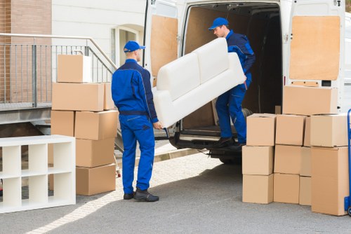 Household moving boxes and furniture arranged for a local removals service